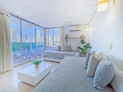 a living room with a couch and a large window at Riviera Summer - Apartamento con balcón in Cartagena de Indias