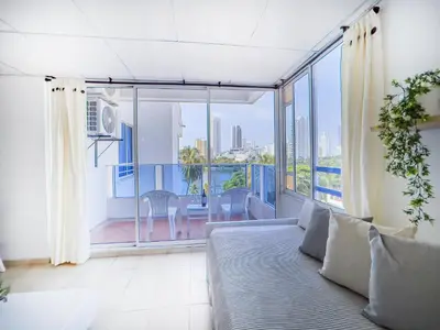a living room with a couch and a large window at Riviera Summer - Apartamento con balcón in Cartagena de Indias