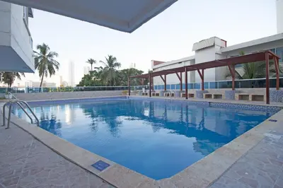 a large swimming pool with blue water in a building at Riviera Summer - Apartamento con balcón in Cartagena de Indias
