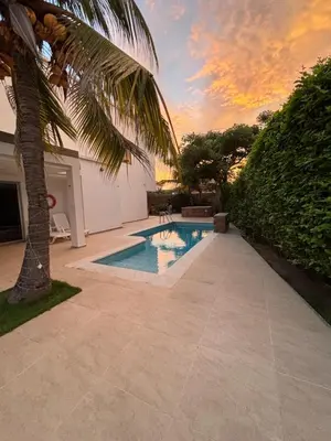 a swimming pool with a palm tree in a backyard at Cabaña Belmar House in Puerto Salgar