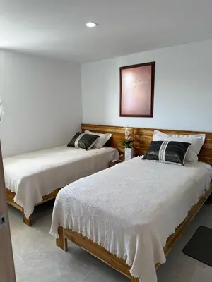 two beds in a room with white walls at Luxury Apartments in Barranquilla