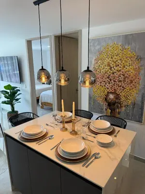 a dining table with plates and utensils and a painting at Luxury Apartments in Barranquilla