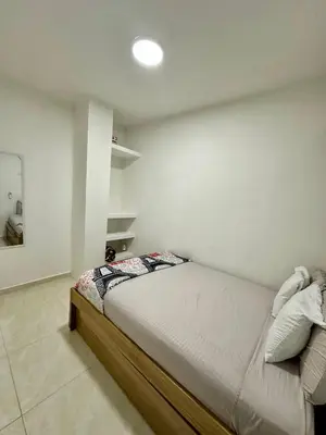 a bed in a room with a white wall at Casa Murillo Toro in Cartagena de Indias