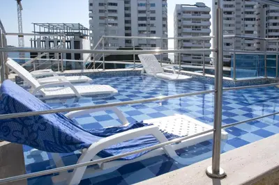 a balcony with chairs and a swimming pool on a roof at Alojamiento en Torres del Lago in Cartagena de Indias