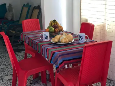 a table with red chairs and a plate of fruit at Bogavante Getsemani para familias in Cartagena de Indias