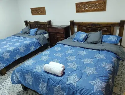 a bedroom with two beds with blue comforter and a towel at Bogavante Getsemani para familias in Cartagena de Indias