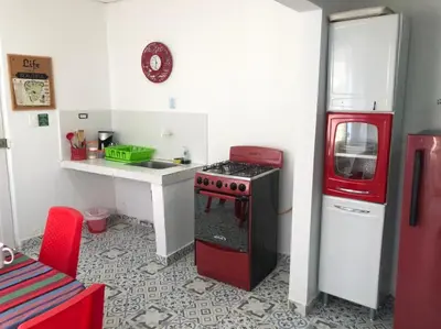 a small kitchen with a red stove and a sink at Bogavante Getsemani para familias in Cartagena de Indias
