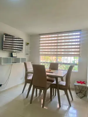 a dining room with a table and chairs and a laptop at Apartamento acogedor y económico in Barranquilla