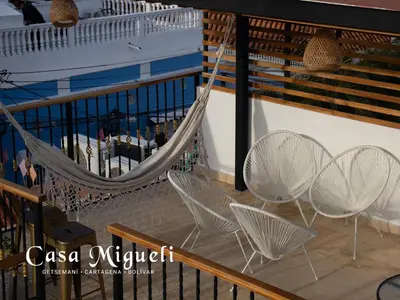 a hammock on a balcony with a cruise ship at Casa Migueli, exclusiva casa con jacuzzi en terraza in Cartagena de Indias
