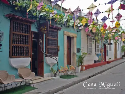 a street with chairs and kites hanging from a building at Casa Migueli, exclusiva casa con jacuzzi en terraza in Cartagena de Indias