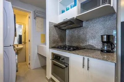 a small kitchen with a stove and a refrigerator at Clifford Place Morros epic - Direct Beach Access in Cartagena de Indias