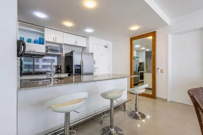 a kitchen with two stools and a counter top at Clifford Place Morros epic - Direct Beach Access in Cartagena de Indias