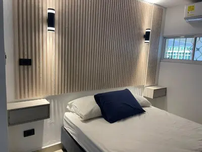 a bedroom with a bed with a blue pillow on it at Apartaestudio Barranquilla in Barranquilla