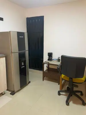 an office with a chair and a desk and a refrigerator at Apartaestudio Barranquilla in Barranquilla