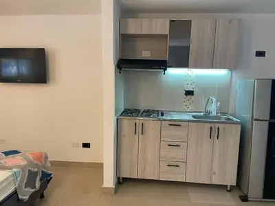 a kitchen with a sink and a refrigerator at Apartaestudio Barranquilla in Barranquilla