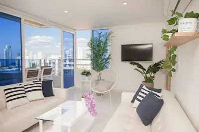 a living room with a white couch and some plants at Riviera del Mar - Apartamento con vista panorámica al mar in Cartagena de Indias