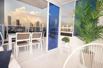 a balcony with a table and chairs and a view of the city at Riviera del Mar - Apartamento con vista panorámica al mar in Cartagena de Indias