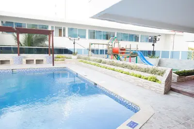 a swimming pool with a playground in front of a building at Riviera del Mar - Apartamento con vista panorámica al mar in Cartagena de Indias