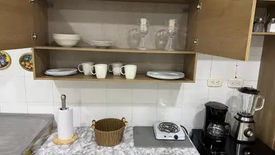 a kitchen counter with cups and plates and a blender at aparta estudio susheria in Sincelejo