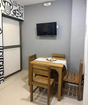 a table and chairs with a television on a wall at aparta estudio susheria in Sincelejo