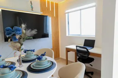 a dining room with a table with chairs and a laptop at Luxury apartment with sea view in Cartagena de Indias