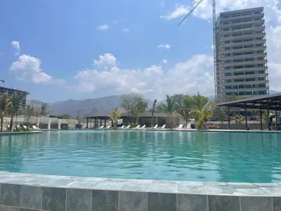 a large swimming pool in a city with a tall building at Maranta Beach in Santa Marta