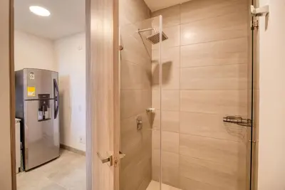 a shower with a glass door next to a refrigerator at Maranta Beach in Santa Marta