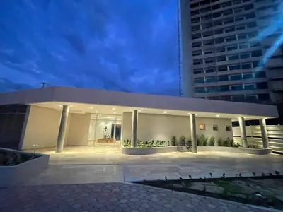 a large white building with columns and a building at Maranta Beach in Santa Marta