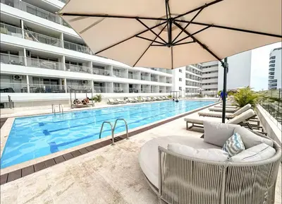 a swimming pool with an umbrella next to a building at Exclusive apartment Cartagena in Cartagena de Indias