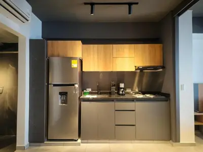 a kitchen with a stainless steel refrigerator and wooden cabinets at Exclusive apartment Cartagena in Cartagena de Indias