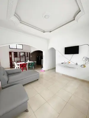 a living room with a couch and a tv on a wall at Casa Ingrid in Coveñas