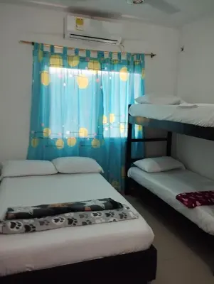 a bedroom with two bunk beds and a blue curtain at Casa Ingrid in Coveñas