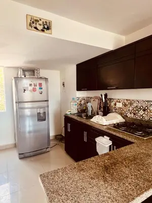 a kitchen with a stainless steel refrigerator and black cabinets at Playa Azul in Puerto Colombia