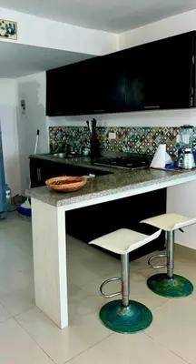 a kitchen counter with two stools and a counter top at Playa Azul in Puerto Colombia