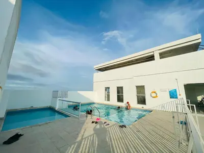 a swimming pool next to a building with people in it at apartamento lindo in Cartagena de Indias