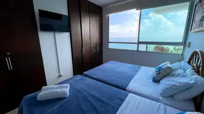 a bedroom with two beds and a window at Magico Apartamento Frente al Mar 3 Habitaciones MSC64 in Coveñas
