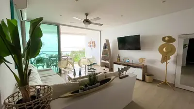 a living room with a white couch and a plant at Magico Apartamento Frente al Mar 3 Habitaciones MSC64 in Coveñas