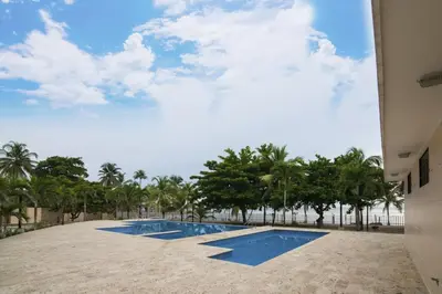 a swimming pool with trees in the background at Magico Apartamento Frente al Mar 3 Habitaciones MSC64 in Coveñas
