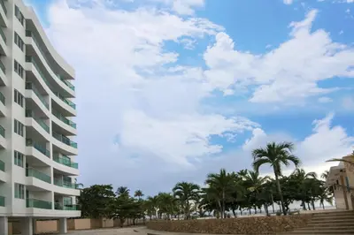 a building with palm trees in front of a building at Magico Apartamento Frente al Mar 3 Habitaciones MSC64 in Coveñas