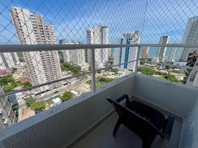 a chair on a balcony with a view of a city at Apto Luxury Cartagena 7 minutos a pie de la playa in Cartagena de Indias