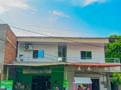 a building with a green and white at Hostal berpé in Coveñas
