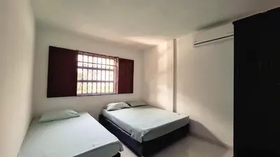 two beds in a small room with a window at Casa Guadalupe Coveñas in Coveñas