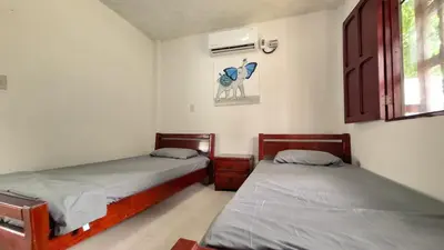 a bedroom with two beds and a window at Casa Guadalupe Coveñas in Coveñas