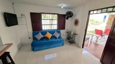 a blue couch with pillows in a living room at Casa Guadalupe Coveñas in Coveñas
