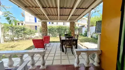 a porch with a table and chairs on it at Casa Guadalupe Coveñas in Coveñas