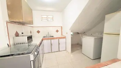 a small white kitchen with a sink and a refrigerator at Casa Guadalupe Coveñas in Coveñas