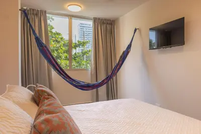 a bed with a hammock in a bedroom with a window at New Pueblito Suites - Cerca a la Playa in Cartagena de Indias