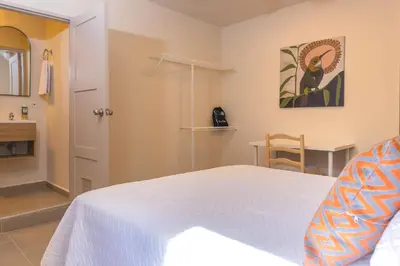 a bedroom with a bed and a table and a chair at New Pueblito Suites - Cerca a la Playa in Cartagena de Indias