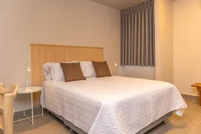 a bedroom with a large bed and a table at New Pueblito Suites - Cerca a la Playa in Cartagena de Indias
