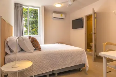 a bedroom with a bed and a window at New Pueblito Suites - Cerca a la Playa in Cartagena de Indias